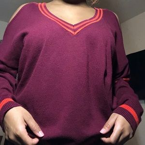 A burgundy long sleeve that has orange accent